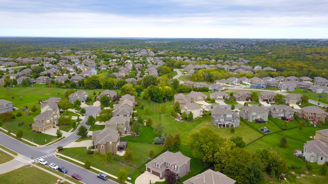 Mastering the First Impression: Your intriguing post title goes here Aerial view of a suburban neighborhood with houses, roads, and lush greenery.