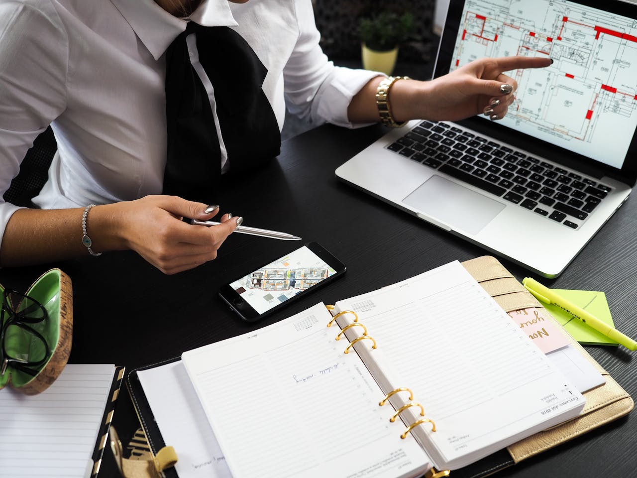 Crafting Captivating Headlines: Your awesome post title goes here A business professional working on real estate project plans using multiple devices in an office setting.